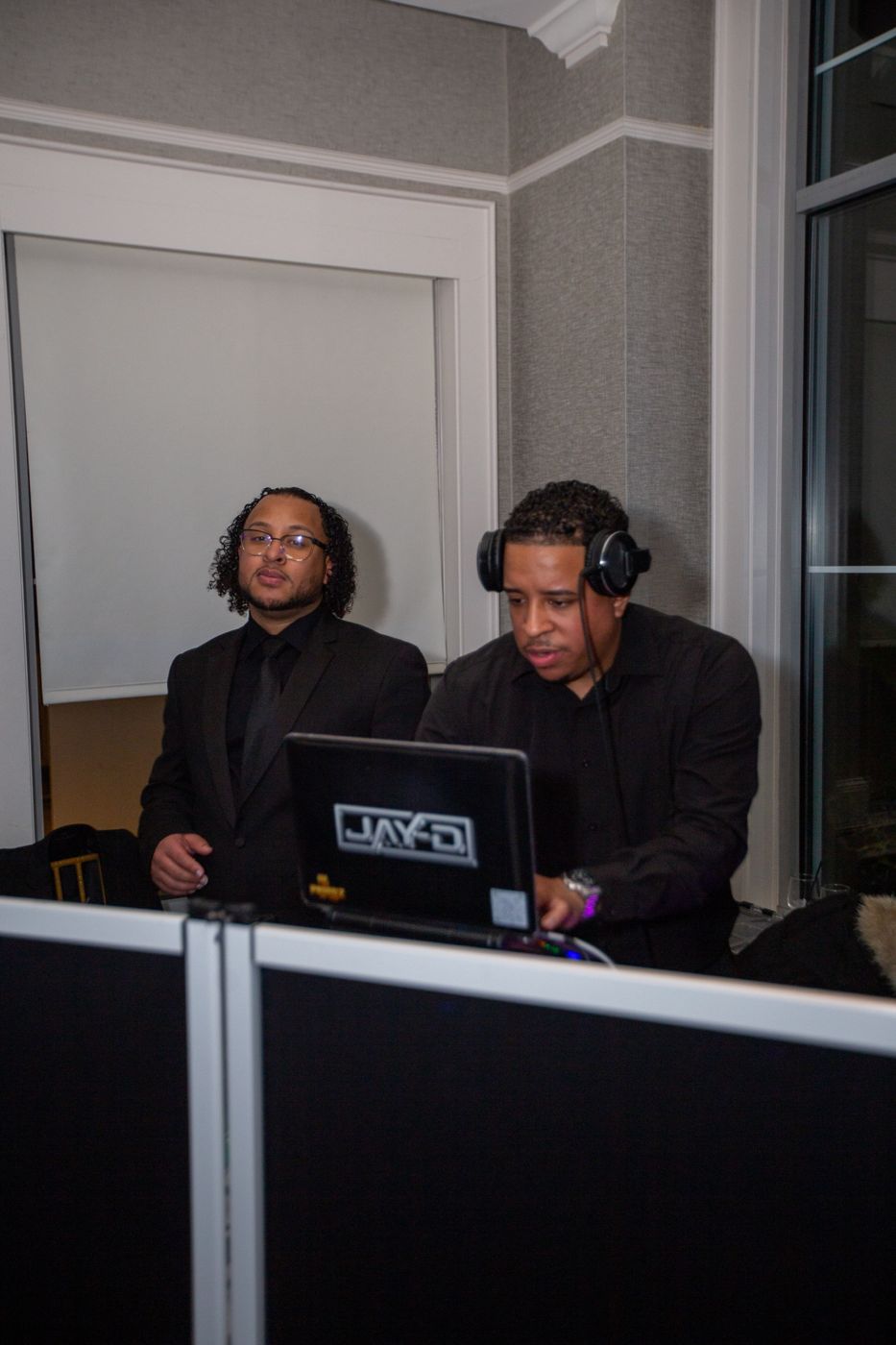 DJ Jay-D at his laptop with a team member beside him