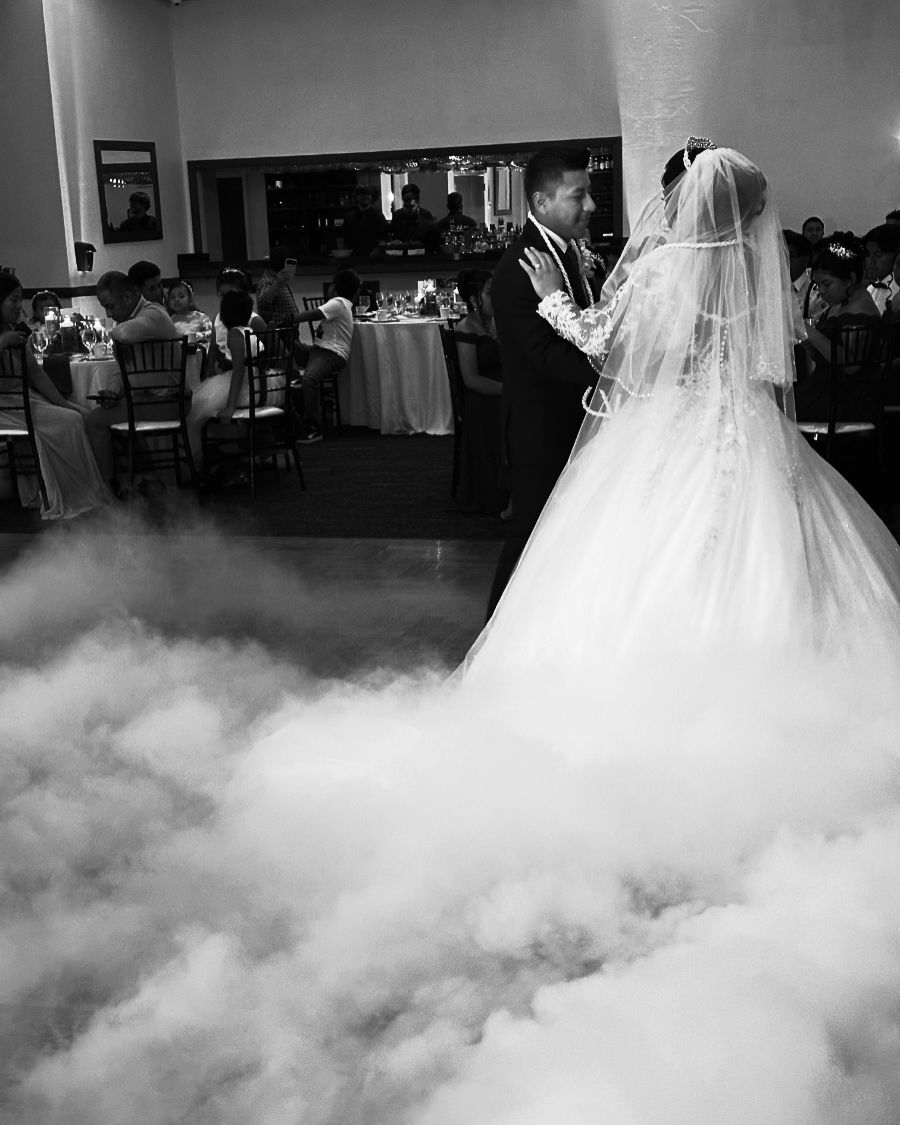 Newlyweds sharing a first dance in low-lying fog