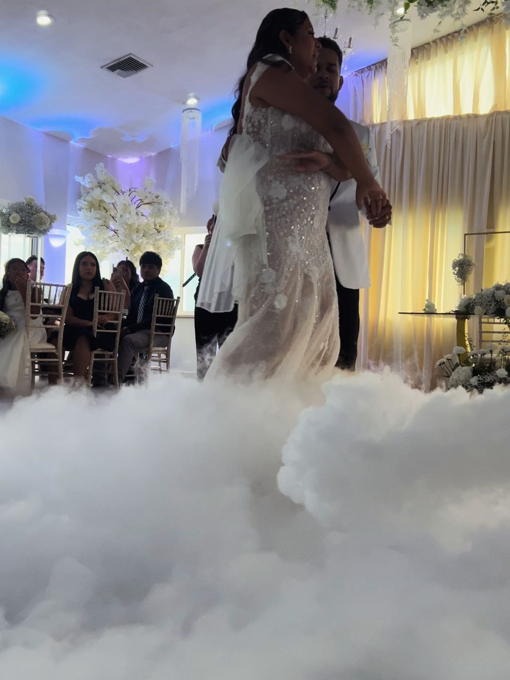Couple dancing in a cloud of fog with blue uplighting