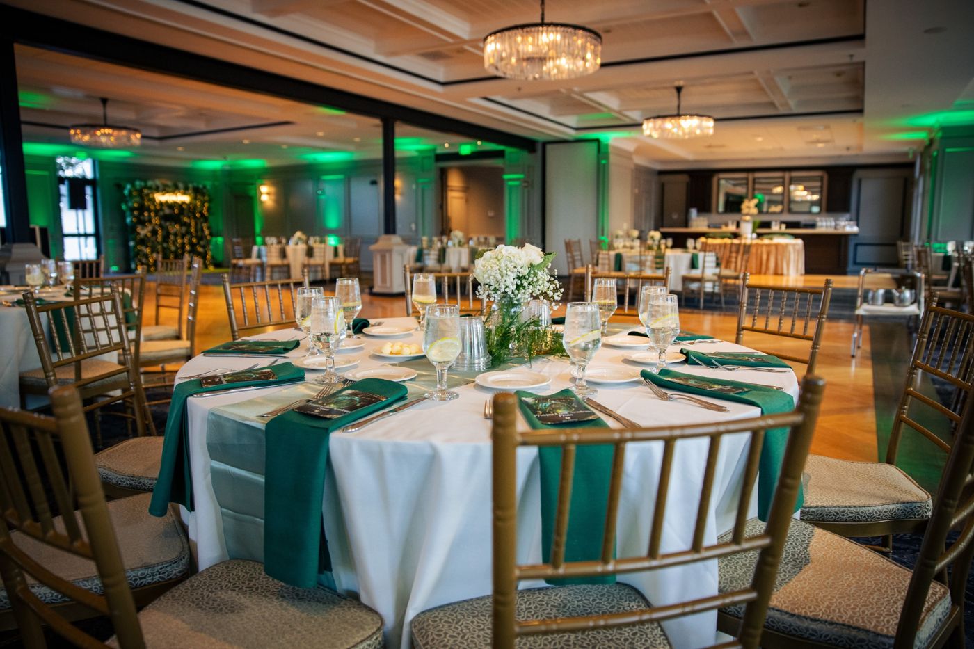 Reception table with green uplighting and chandeliers